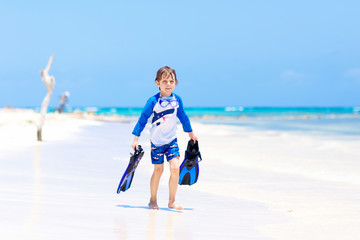 little blond kid boy having fun on tropical beach of Bora Bora
