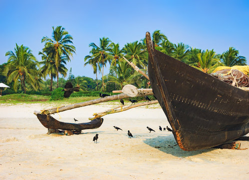 Traditional fishing boat on palm trees background, Cavelossim Beach in South Goa, India
