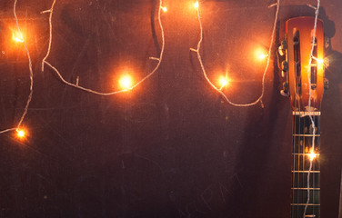 Old guitar on the background of Christmas light,