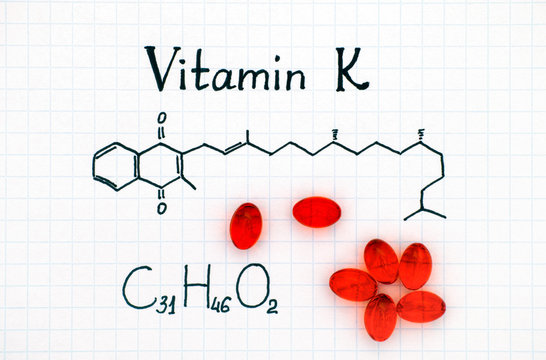 Chemical formula of Vitamin K and red pills.