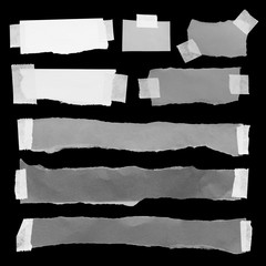 ripped note paper with adhesive tape on a black background