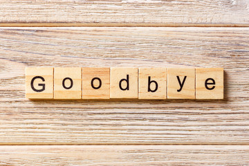 Goodbye word written on wood block. Goodbye text on table, concept