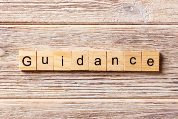 Guidance word written on wood block. Guidance text on table, concept
