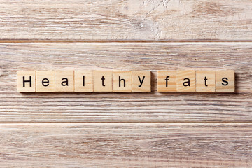 Healthy fats word written on wood block. Healthy fats text on table, concept
