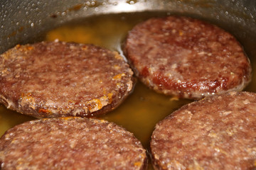 Fried beef cutlets in a frying pan
