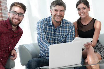 Group of young colleagues using laptop at office