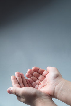 hands folded hands begging alms on a gray background
