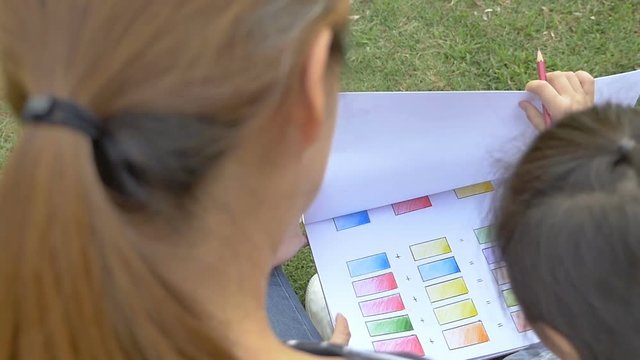 Slow motion of Happy Asian Daughter drawing picture with mother together in the park
