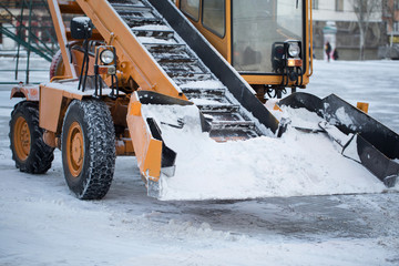 Tractor cleaning the road from the snow. Excavator cleans the streets of large amounts of snow in...