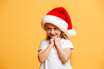 Cheerful girl standing isolated wearing christmas santa hat