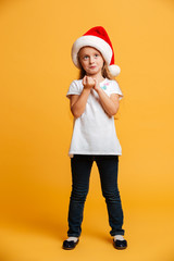 Thoughtful girl standing isolated wearing christmas santa hat.