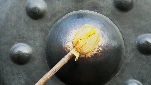 person hand chimes gong in a temple with slow-motion, Chiang Mai Thailand.