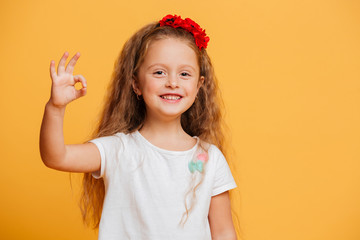 Funny little girl child showing okay gesture.