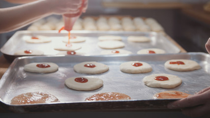 Cooks prepare a mini pizza, place the tomato paste