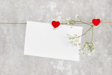 The love letter hangs on rope and a flower on a light background