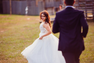 Naklejka premium The beautiful brides running along grass