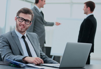 Fototapeta premium Portrait of a handsome young business man with people in background at office meeting