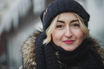 portrait of beautiful happy smiling woman posing outdoors in winter.