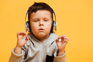Concentrated boy child sitting on floor listening music