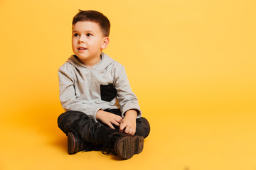 Little boy child sitting on floor isolated