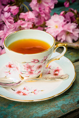 Beautiful, vintage teacup with Japanese cherry tree blossoms, shot from above.
