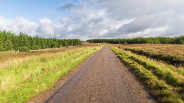 hyperlaspe POV shot from a camera attached to the front of a vehicle driving through beautiful empty roads in the scottish highlands
