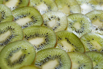 Bright green background with slices of juicy kiwi. Healthy food background.