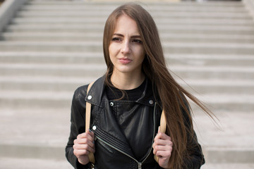Obraz premium Young beautiful sexy woman in black skin clothes outdoors