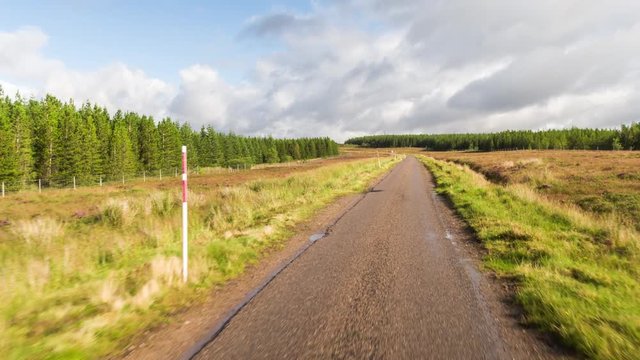 POV shot from a camera attached to the front of a vehicle driving through beautiful empty roads in the scottish highlands