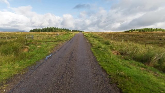 POV shot from a camera attached to the front of a vehicle driving through beautiful empty roads in the scottish highlands
