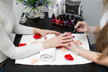 Master applying polish on fingernails on woman