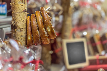 Traditional baked pretzels, hang on the market stall on a stand. On a writable sign you can leave a text. Concept: markets, festivals, food