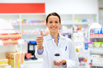 apothecary with drug showing thumbs up at pharmacy