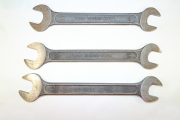 tools for work, four steel spanners in different positions on a white background