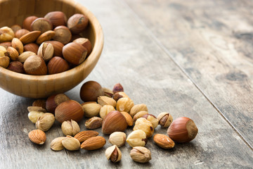 Assorted mixed nuts in bowl on wooden table