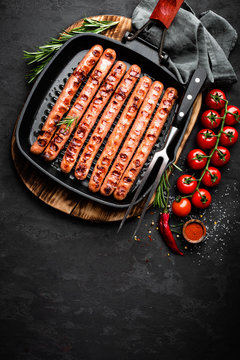 Grilled sausages bratwurst in grill frying-pan on black background. Top view. Traditional German cuisine. Stock image