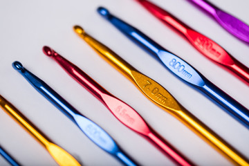 Colored hooks for wool knitting on white background
