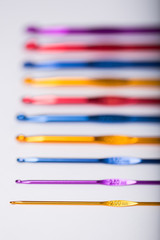 Colored hooks for wool knitting on white background