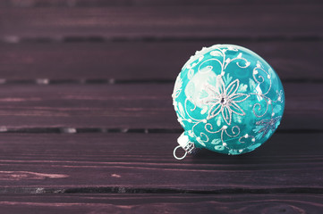 Fototapeta na wymiar Turquoise Christmas ball on a wooden background.