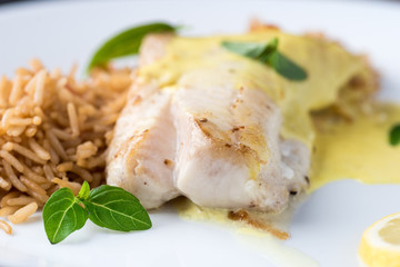 Grilled fish with rice and lemon sauce