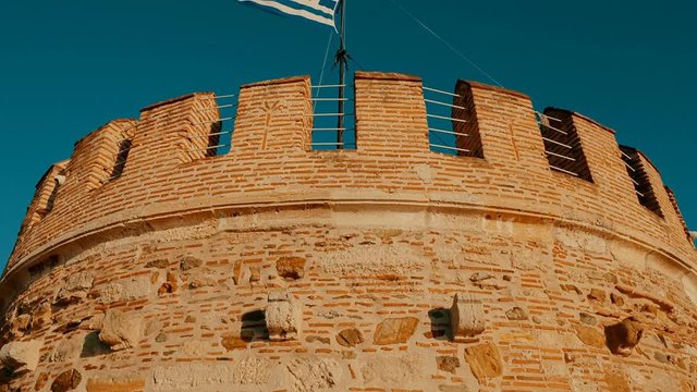 Telephoto sunset golden hour shot of the top of White Tower, an icon of Thessaloniki, Greece. Its construction dates back to 1423. Thessaloniki is the second major commercial center of Greece