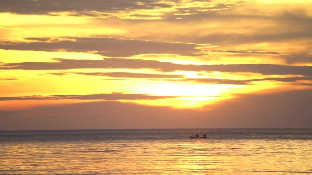 couple sea kayaking at sunset