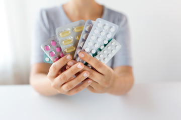 woman hands holding packs of pills