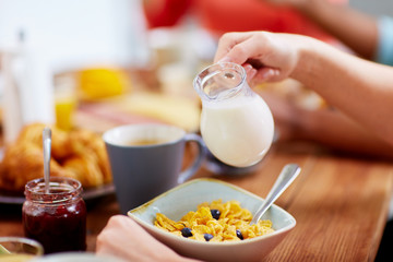 hands of woman eating cereals for breakfast