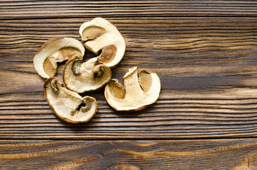 White dried mushrooms on wooden background ready for cooking