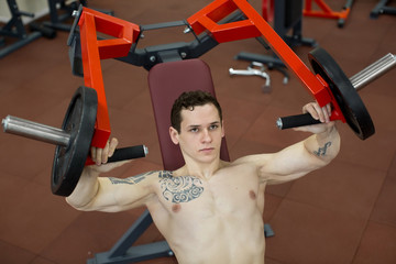 Man doing chest exercises on vertical bench press machine