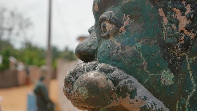 Muzzled slave door keeper in Ouidah, close up