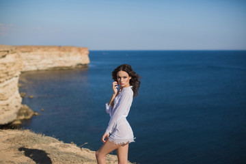 Fototapeta na wymiar Girl in lingerie on top of a mountain overlooking the ocean.