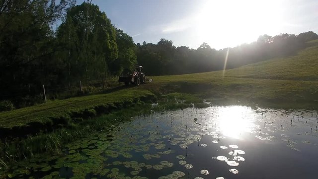 tractor drives past lilypond and the sunset flyover