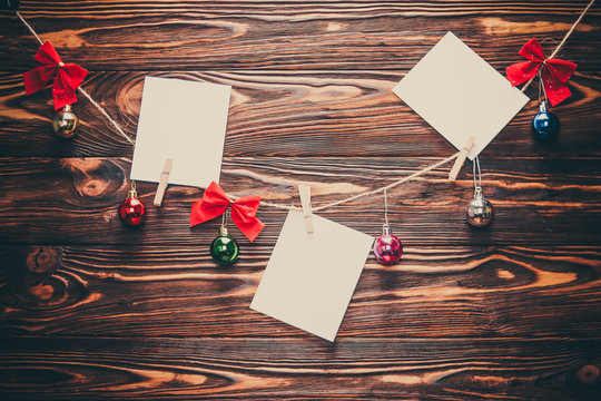 White notes on wooden background with christmas decor